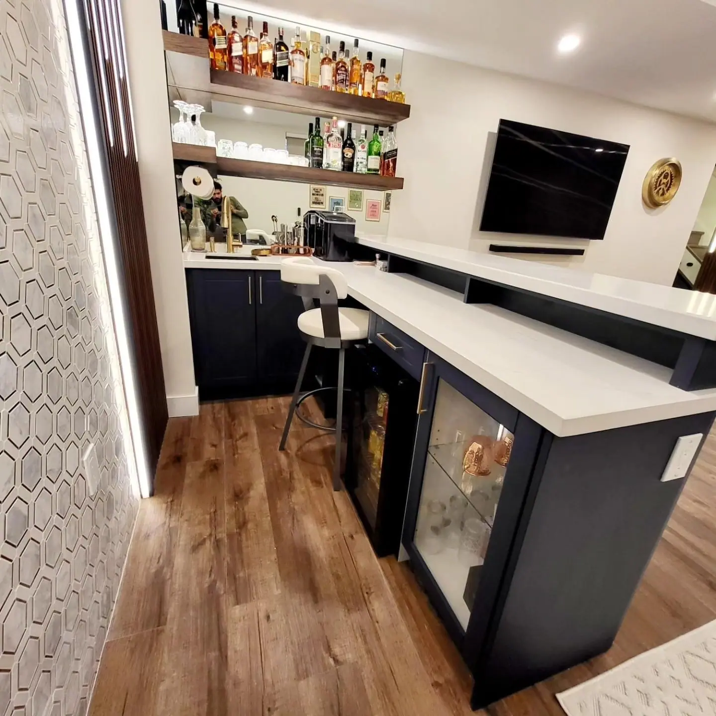 Basement bar with floating shelves, wine fridge and quartz counter