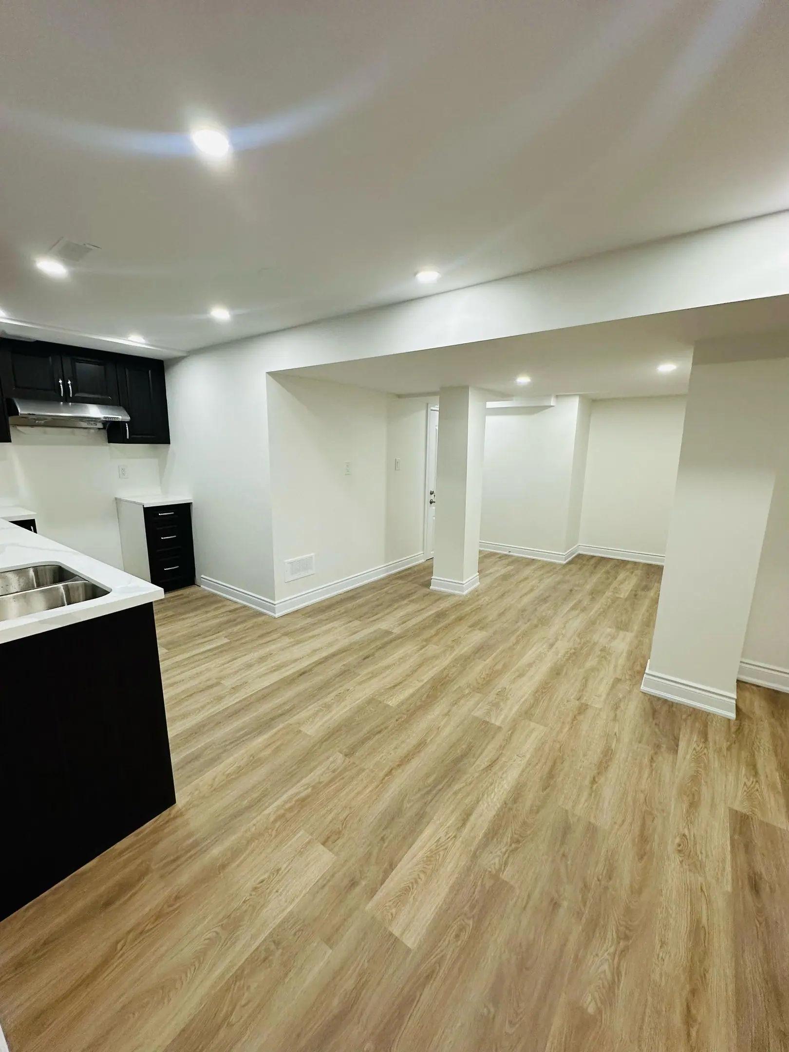 Basement living space opening to a black kitchen island