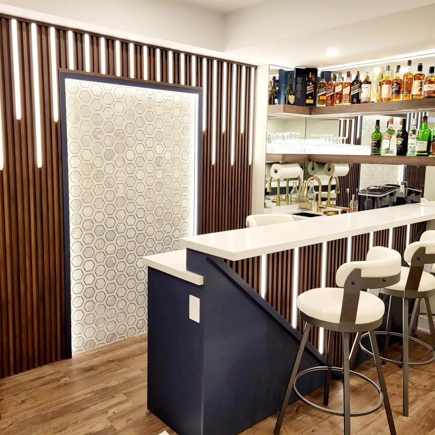 Basement wet bar with walnut slat wall, quartz counter and bar stools