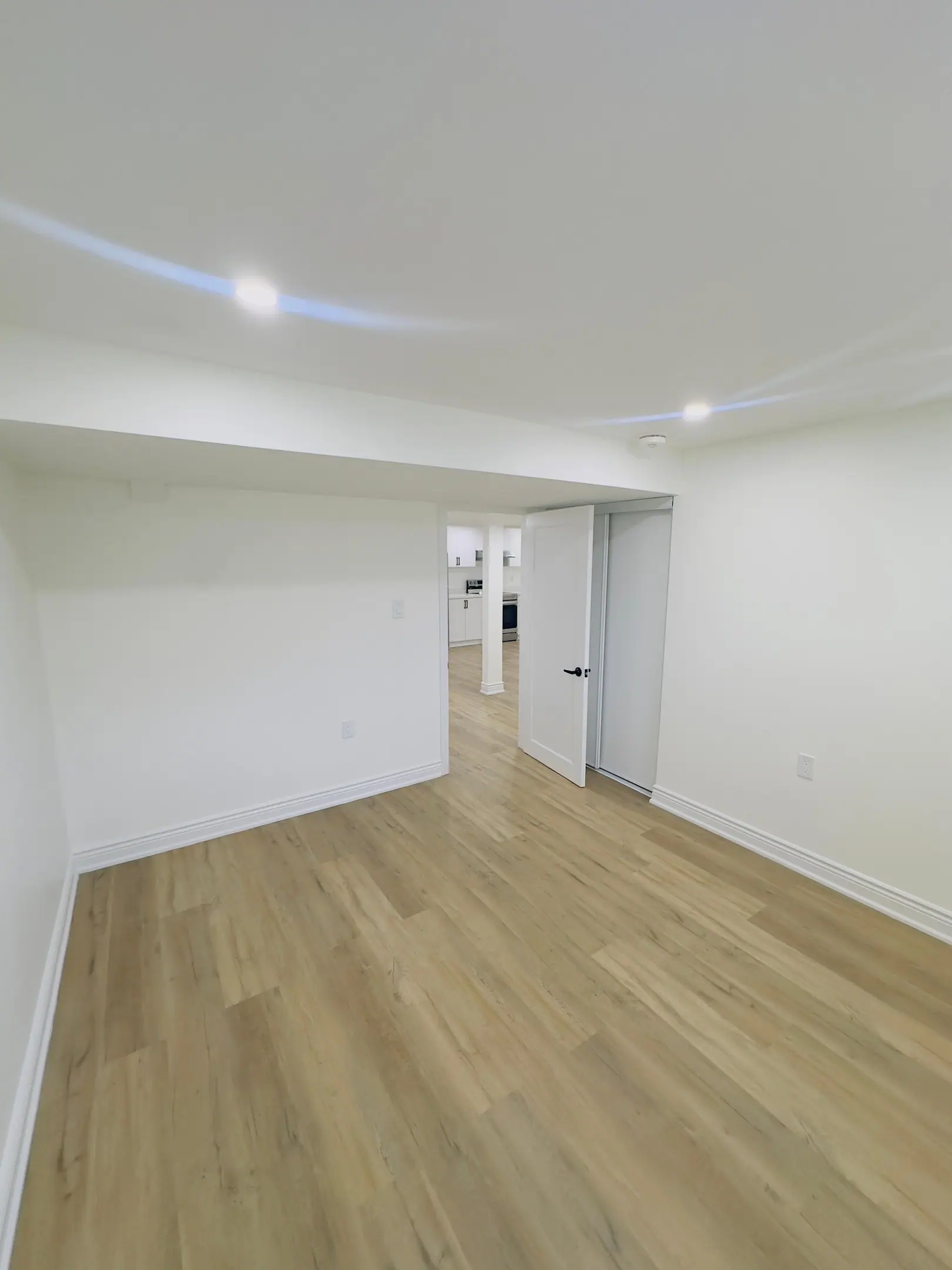 Long open basement recreation room with pot lights