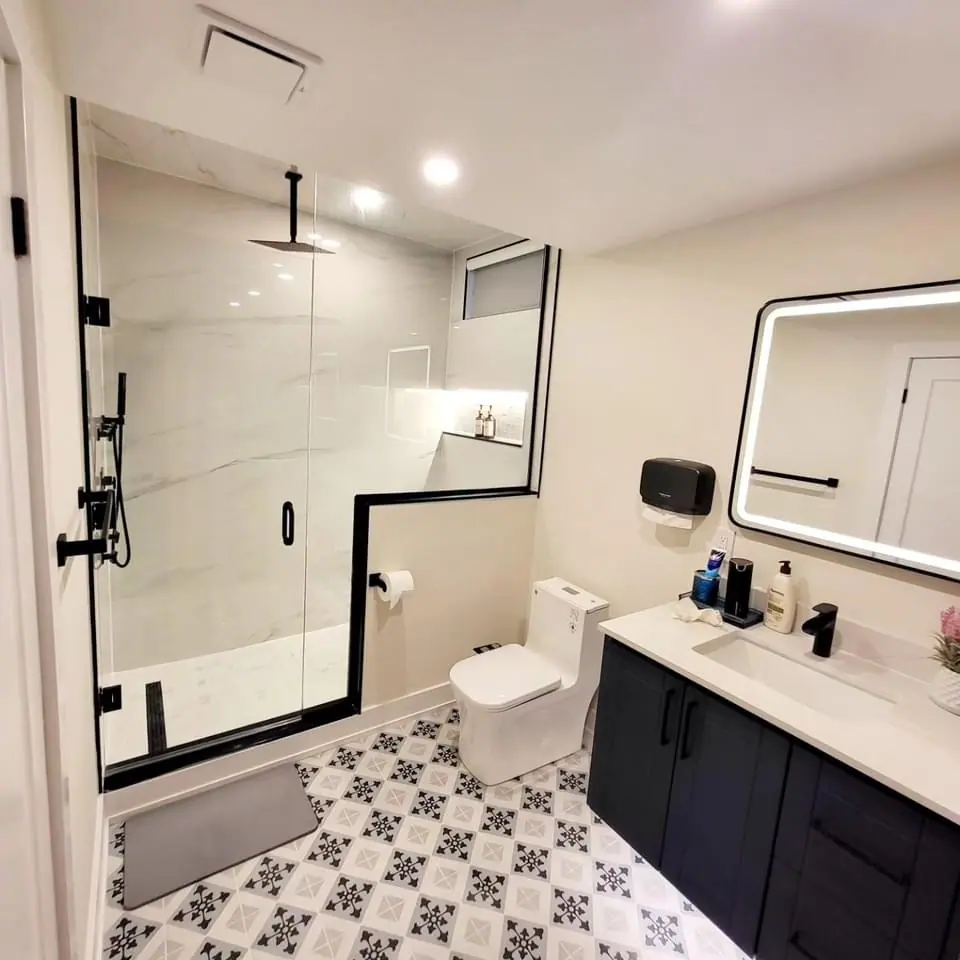 Bathroom with black-framed glass shower and patterned floor tile