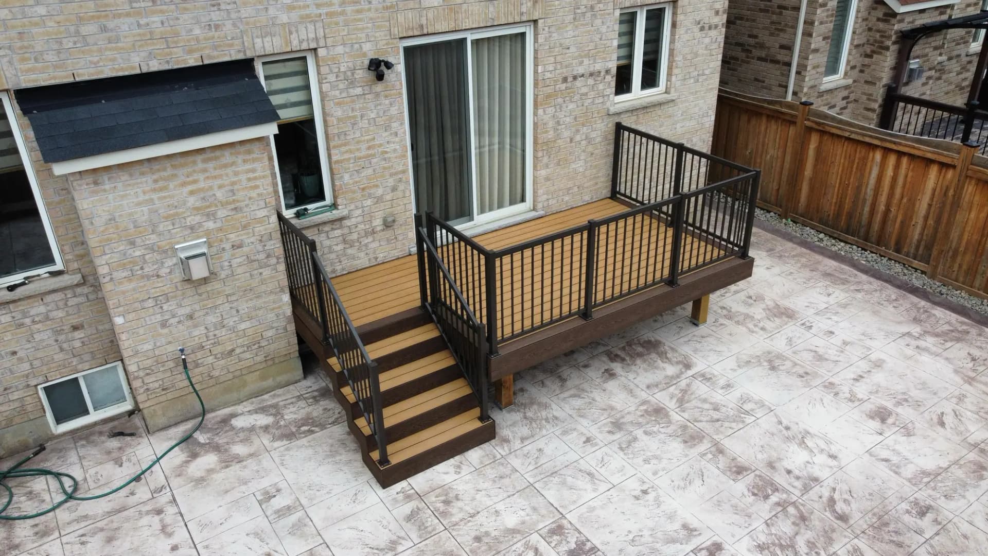 Small deck with black aluminum railing and stairs