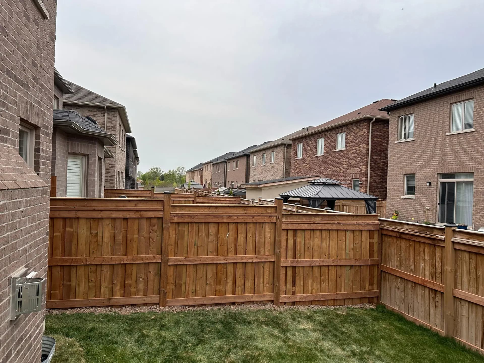 Wood privacy fence enclosing a backyard