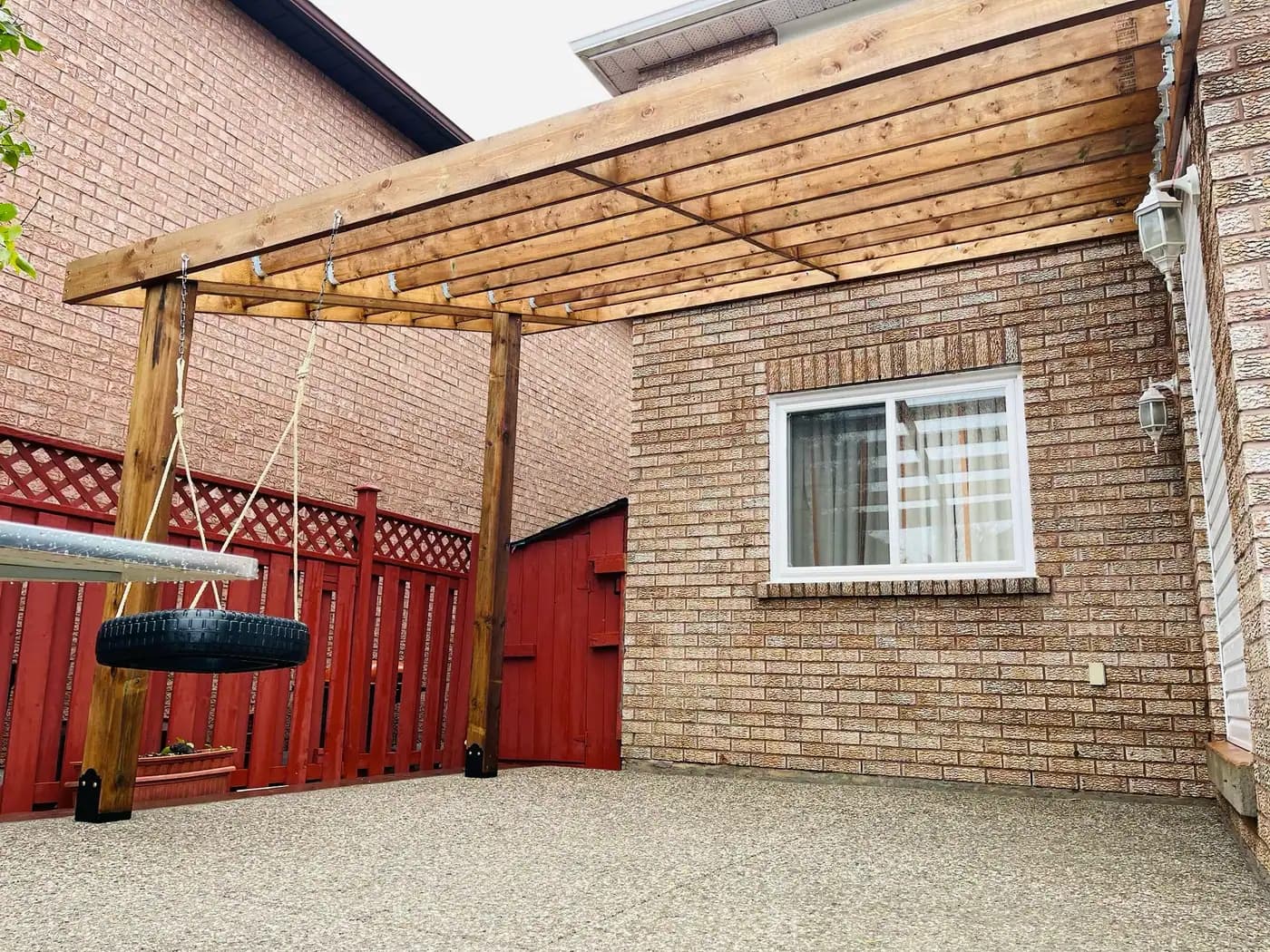 Wood pergola over a concrete patio with privacy screen