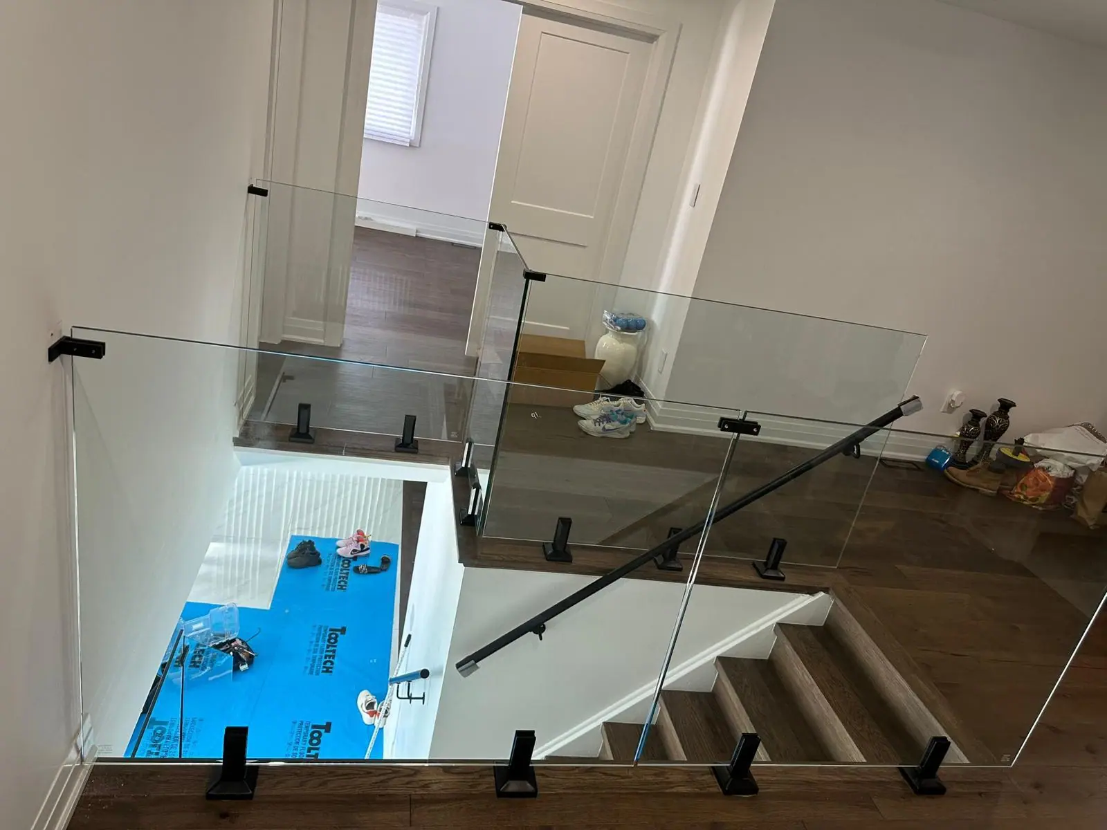 Staircase renovation in progress with new glass railing