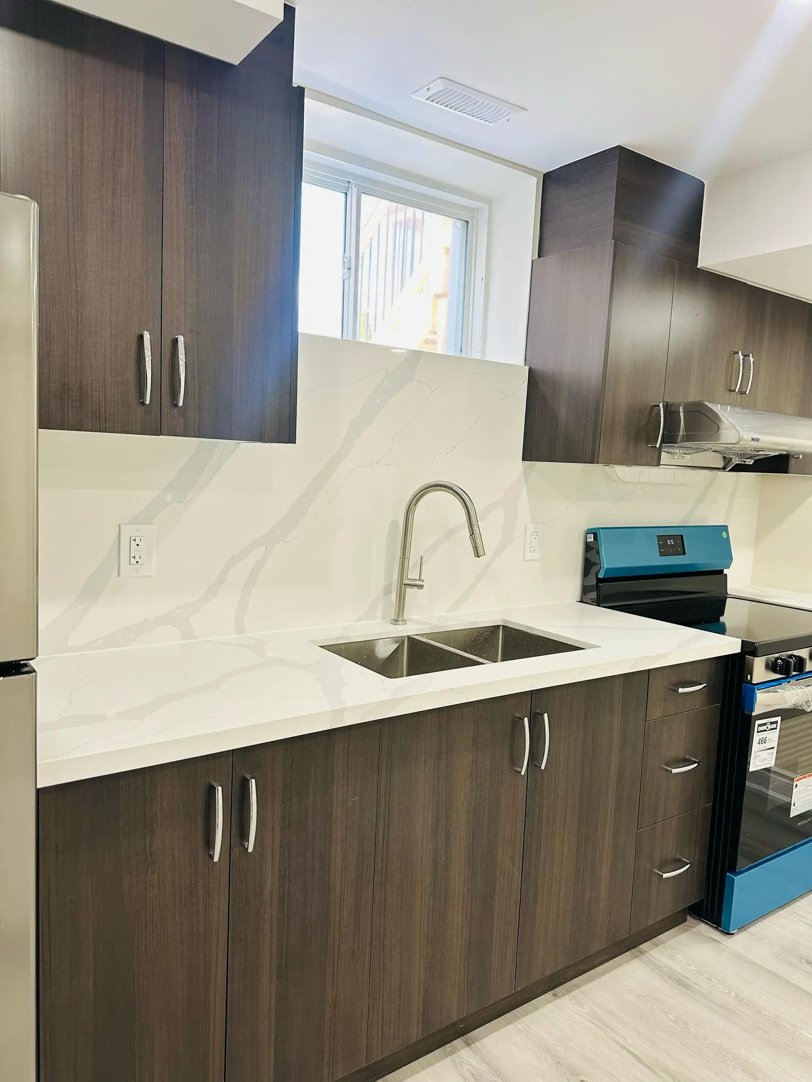 Dark wood kitchen with quartz backsplash and range