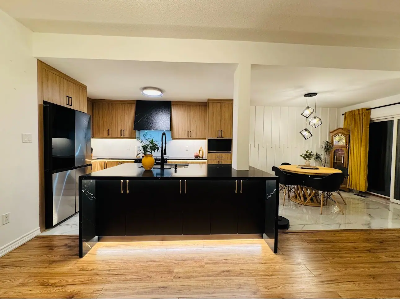 Wood kitchen with black island and adjoining dining area