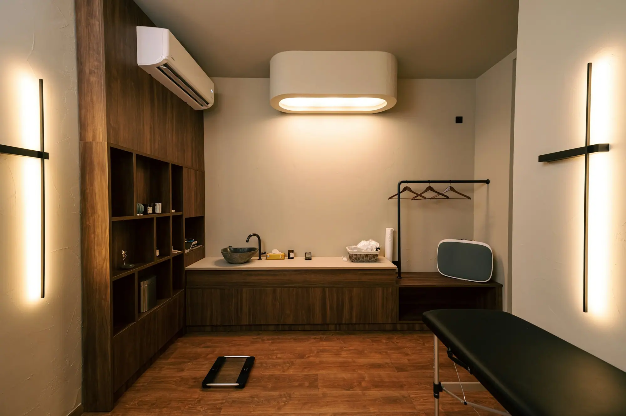 Medical exam room with wood millwork, sink area and exam table